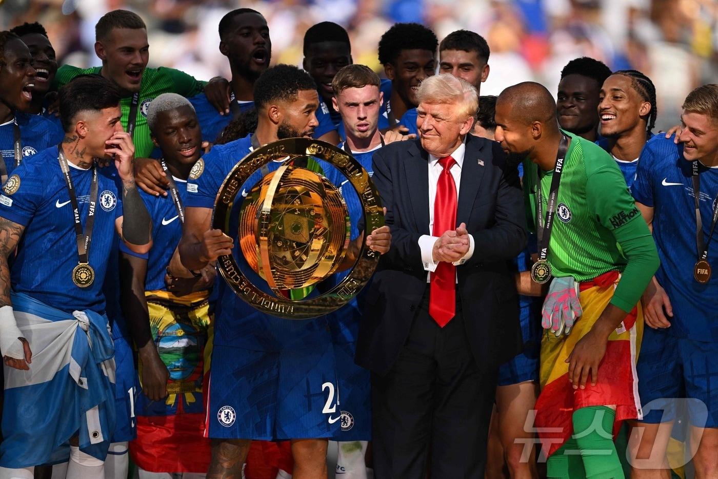 13일(현지시간) 미국 뉴저지주 메트라이프 스타디움에서 열린 첼시 FC와 파리 생제르맹 간의 FIFA 클럽 월드컵 2025 결승전 경기 후, 첼시 FC의 24번 리스 제임스가 팀의 승리 후 클럽 월드컵 트로피를 들고 있는데 옆에 트럼프 대통령이 서 있다. 2025.07.13 ⓒ AFP=뉴스1 ⓒ News1 최종일 선임기자