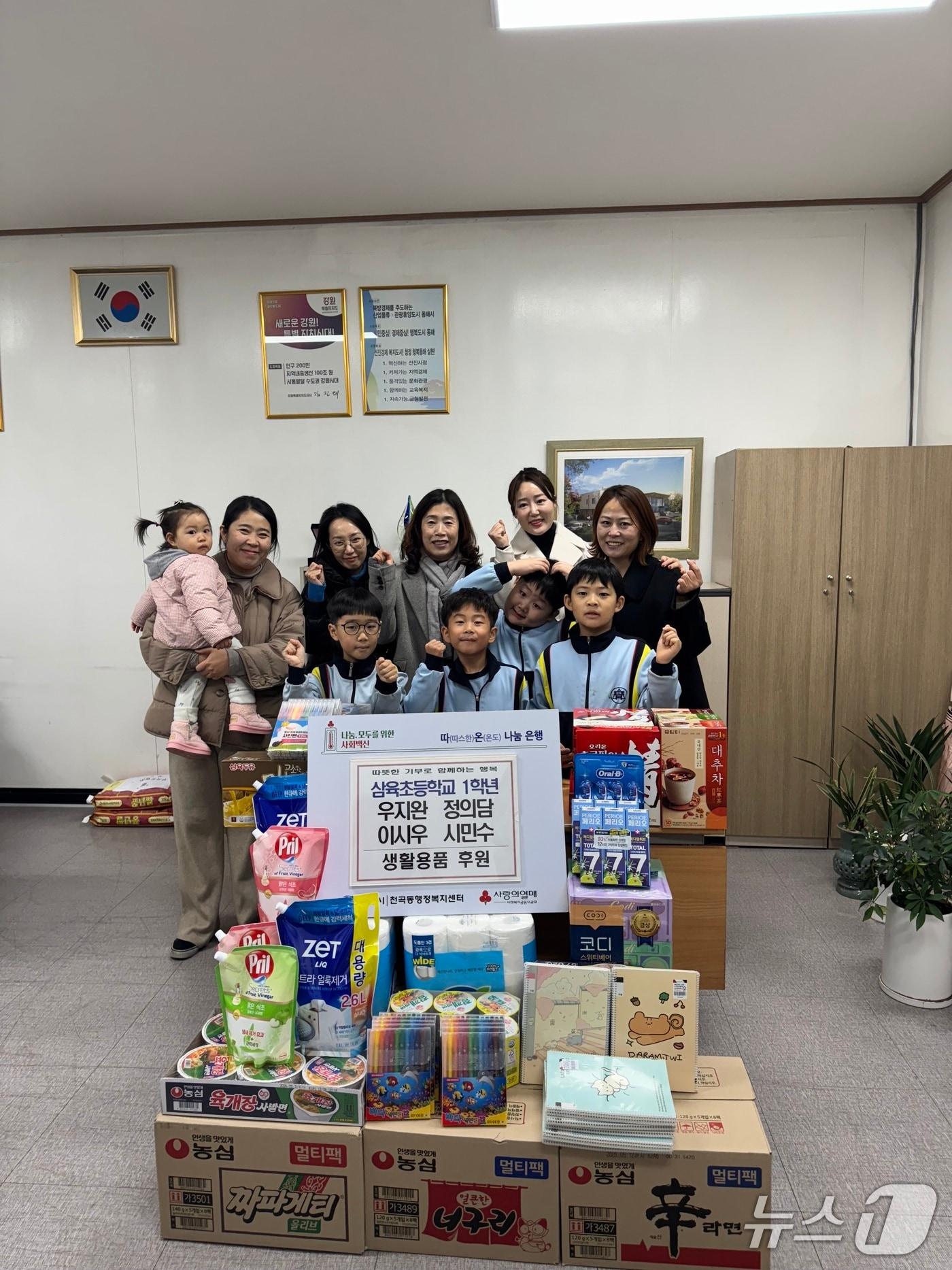 본문 이미지 - 강원 동해 삼육초 1학년 삼육초 1학년 우지완·정의담·이시우·시민수 어린이가 용돈을 모아 마련한 식료품. 식료품을 전달하고 어린이들과 부모, 관계자들이 기념촬영을 하고 있다.(동해시 제공, 재판매 및 DB 금지) 2025.12.16/뉴스1
