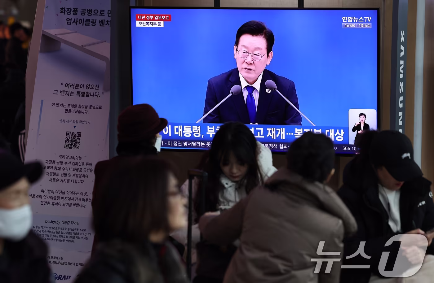 16일 오후 서울 용산구 서울역 대합실 텔레비전을 통해 이재명 대통령의 보건복지부 등에 대한 업무보고 영상이 생중계되고 있다. 2025.12.16/뉴스1 ⓒ News1 구윤성 기자