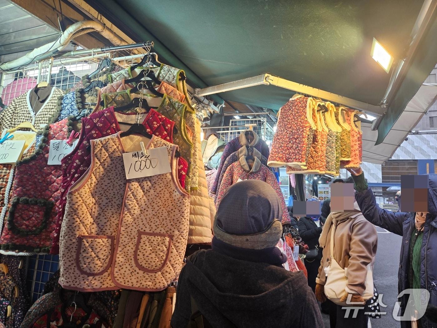 본문 이미지 - 16일 오전 서울 중구 남대문시장에서 외국인 관광객들이 김장조끼를 살펴보고 있다. 2025.12.16/ⓒ 뉴스1 유채연 기자