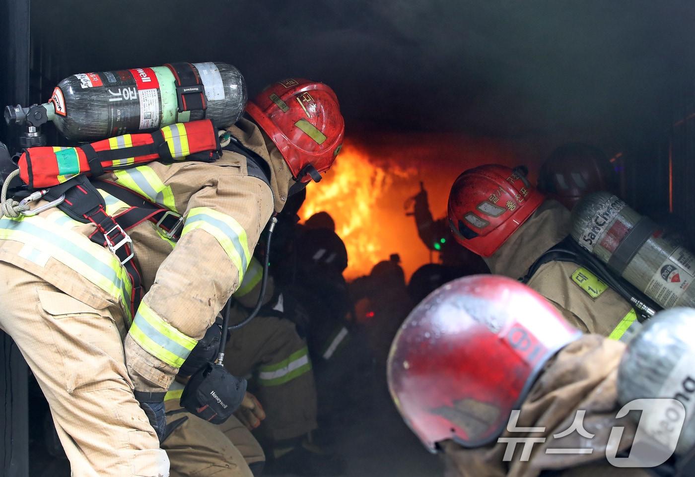 본문 이미지 - 16일 오후 대구 동구 대구소방교육안전센터에서 열린 '실화재 종합훈련 역량강화 특별교육'에 참여한 소방관들이 컨테이너 모형주택 내부에서 불과 연기가 번지는 과정과 창 또는 문 개방에 따른 내부 상황 변화를 지켜보고 있다. 2025.12.16 ⓒ 뉴스1 공정식 기자