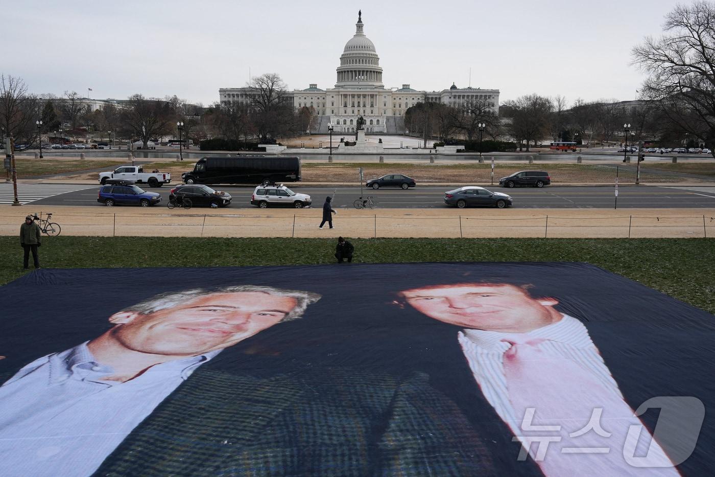 본문 이미지 - 지난해 12월 15일(현지시간) 미국 워싱턴DC 내셔널몰에 전시된 도널드 트럼프 대통령과 고(故) 제프리 엡스타인이 과거에 함께 찍은 사진. 2025.12.15 ⓒ 로이터=뉴스1 ⓒ News1 김경민 기자