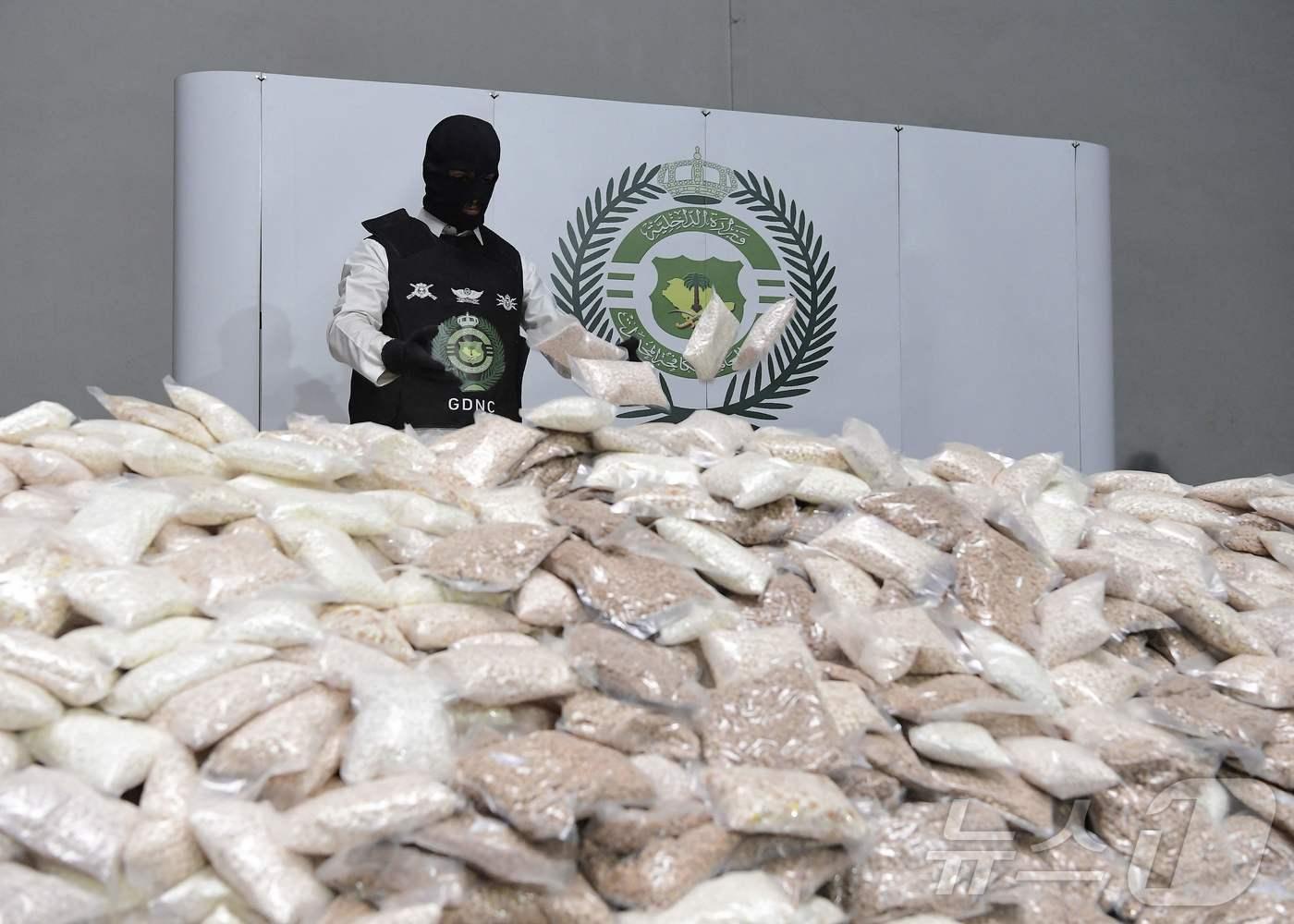 본문 이미지 - 2022년 8월 31일 사우디 내무부가 공개한 사진에서 한 보안 요원이 알려지지 않은 창고에서 암페타민 알약이 담긴 자루들을 쌓고 있다. 2022.08.31. ⓒ AFP=뉴스1 ⓒ News1 이정환 기자