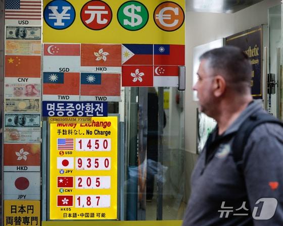 본문 이미지 - 한 외국인이 명동에 있는 환전소 앞을 지나가고 있다./뉴스1 안은나 기자