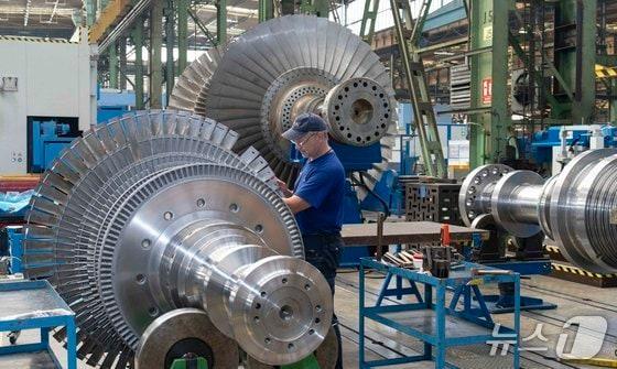 본문 이미지 - 체코 플젠에 위치한 두산에너빌리티의 체코 자회사 두산스코다파워 공장에서 직원이 증기터빈을 살펴보고 있다.(두산에너빌리티 제공)