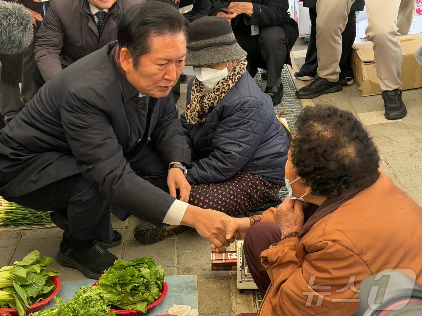 본문 이미지 - 정청래 더불어민주당 대표와 육동한 춘천시장 등이 17일 강원 춘천 온의동 풍물시장에서 상인과 인사를 나누고 있다. 2025.12.17/뉴스1 ⓒ News1 한귀섭 기자