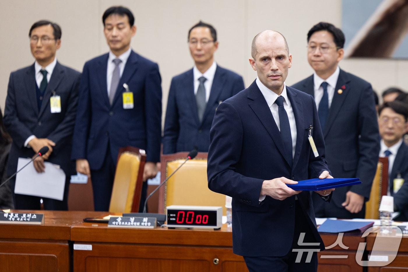 해롤드 로저스 쿠팡 임시 대표가 17일 서울 여의도 국회 과학기술정보방송통신위원회에서 열린 쿠팡 개인정보 유출 사고 관련 청문회에서 증인 선서를 마친 후 최민희 과방위원장에게 선서문을 전달하기 위해 이동하고 있다. 2025.12.17/뉴스1 ⓒ News1 유승관 기자
