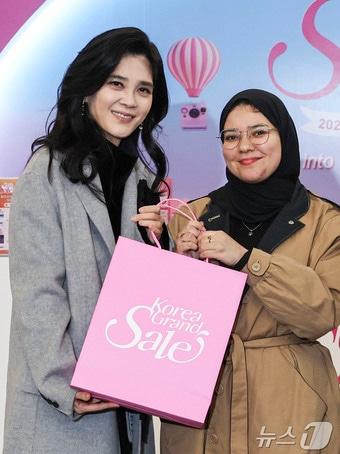 본문 이미지 - 이부진 한국방문의해위원장이 17일 서울 중구 코리아그랜드세일 웰컴센터에서 외국인 방문객에게 기념품을 증정 후 기념사진을 찍고 있다. (공동취재) 2025.12.17 ⓒ 뉴스1 이호윤 기자