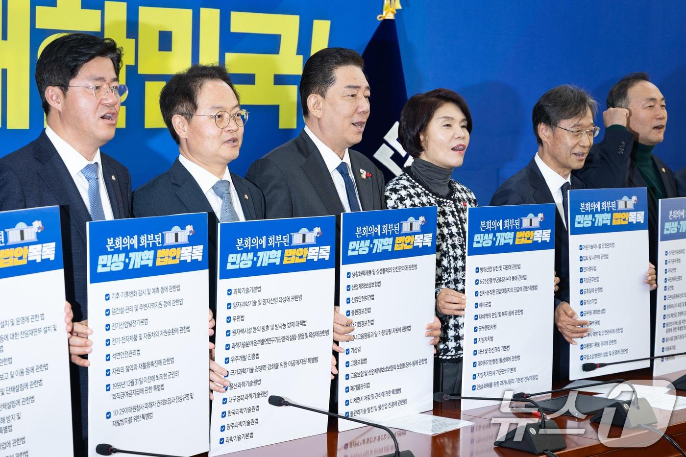 김병기 더불어민주당 원내대표를 비롯한 원내지도부가 18일 서울 여의도 국회에서 열린 정책조정회의에 앞서 본회의에 회부된 민생·개혁 법안목록 손팻말을 들고 국민의힘을 규탄하고 있다. ⓒ News1 유승관 기자