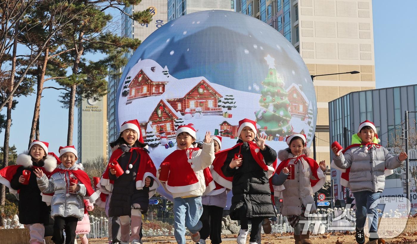 산타 복장을 차려입은 송파구청 어린이집 아이들이 18일 오전 서울 송파구 석촌호수 더 스피어에서 놀이를 하고 있다. 송파구는 연말연시를 맞아 더 스피어를 통해 크리스마스와 새해를 주제로 한 미디어아트를 상영한다. 2025.12.18/뉴스1 ⓒ News1 장수영 기자