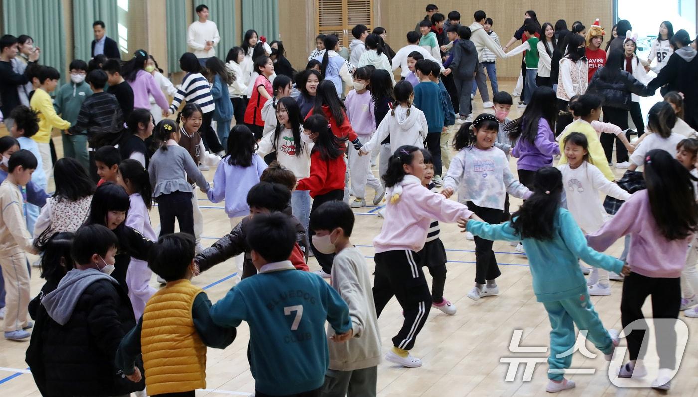 본문 이미지 - 18일 부산 사상구 감전초등학교에서 열린 '감전초·괘법초 만남의 날' 행사에서 괘법초 학생들과 감전초 학생들이 레크레이션을 하고 있다. 저출생으로 인한 학생 수 감소로 올해를 마지막으로 문을 닫는 괘법초는 내년 3월 1일부로 감천초에 통합된다. 2025.12.18 ⓒ 뉴스1 윤일지 기자
