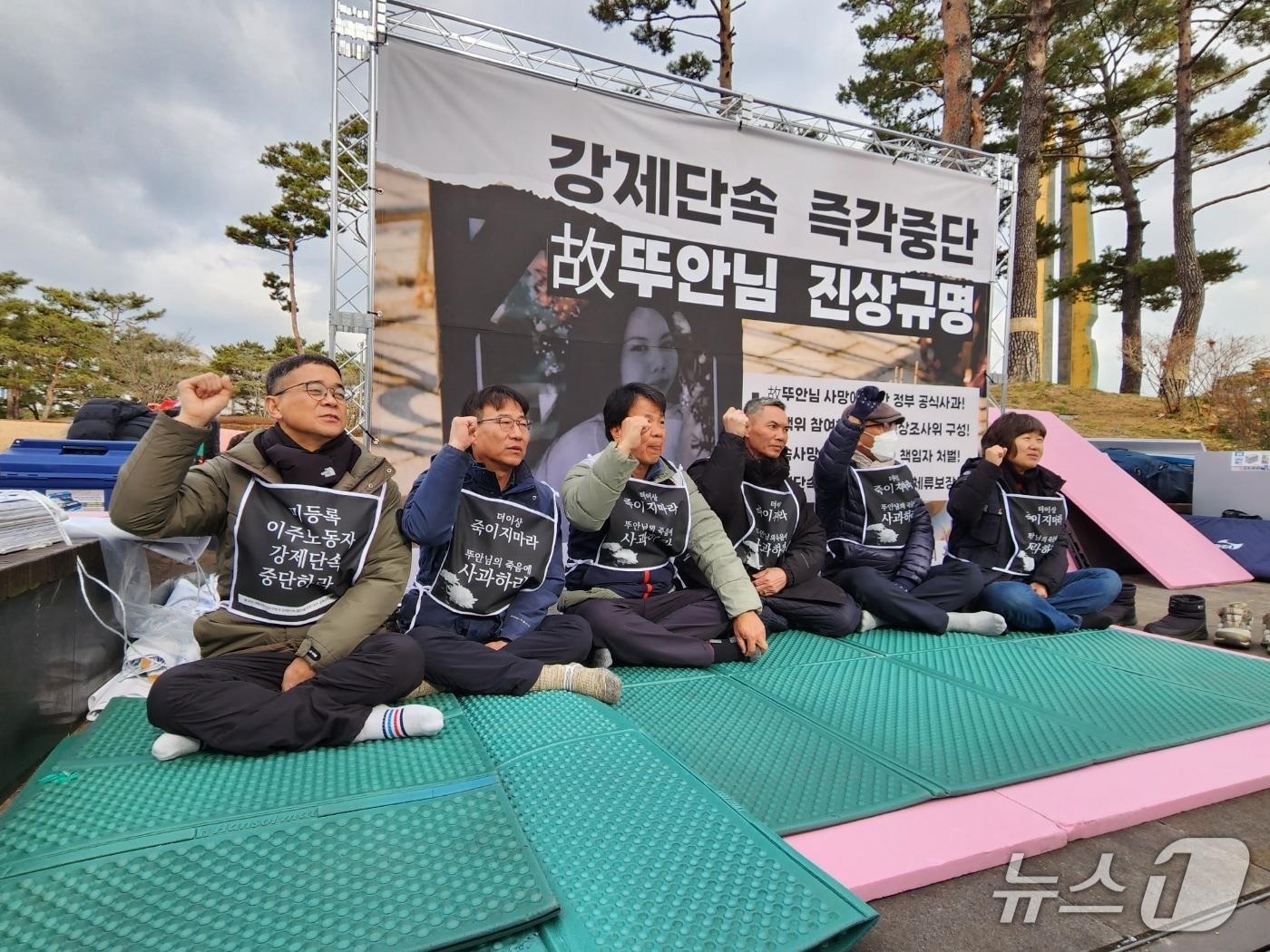 본문 이미지 - 9일 서울시 용산구 대통령실 앞 농성장에서 이주민 노동자 인권 활동가들과 고 뚜안의 아버지 부반숭 씨가 '강제단속 중단'을 촉구하고 있다. 왼쪽에서 두 번째는 이춘기 경주이주노동자센터 소장, 다섯 번째는 김헌주 경북북부이주노동자센터 소장. 2025.12.09/ⓒ 뉴스1 권진영 기자.