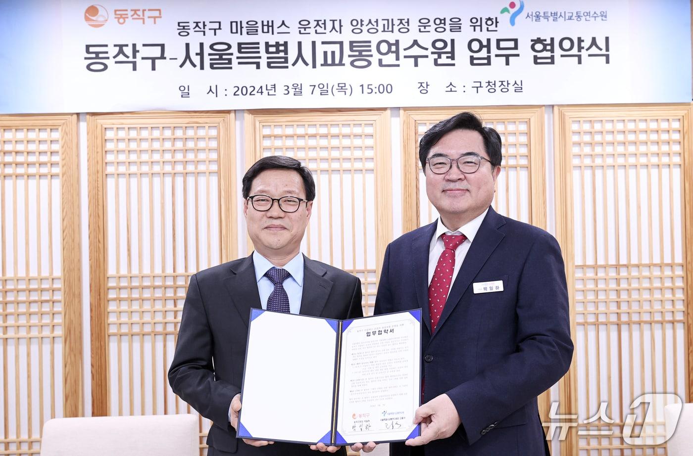 박일하 동작구청장(오른쪽)이 지난해 3월 고홍석 서울시 교통연수원장(왼쪽)과 업무협약을 체결한 후 기념 촬영하고 있다.(서울시 제공)