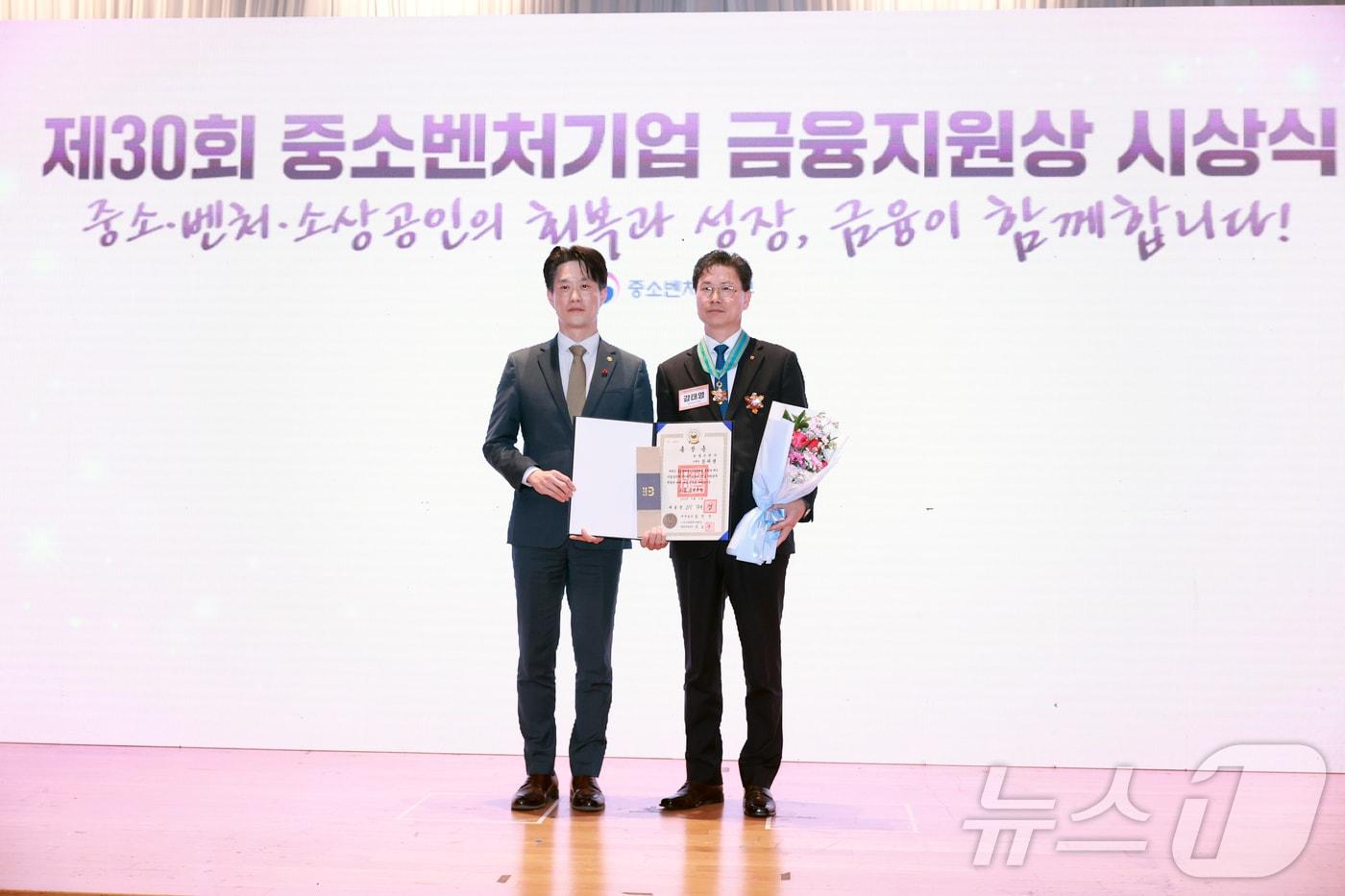 본문 이미지 - 노용석 중소벤처기업부 제1차관이 19일 서울 마포구 중소기업DMC타워에서 열린 '제30회 중소벤처기업 금융지원상 시상식'에서 은탑산업훈장을 받은 강태영 농협은행장과 기념 촬영을 하고 있다. 지난해 금융지원상 시상식의 모습. (중소벤처기업부 제공. 재판매 및 DB 금지) 2025.12.19 ⓒ 뉴스1