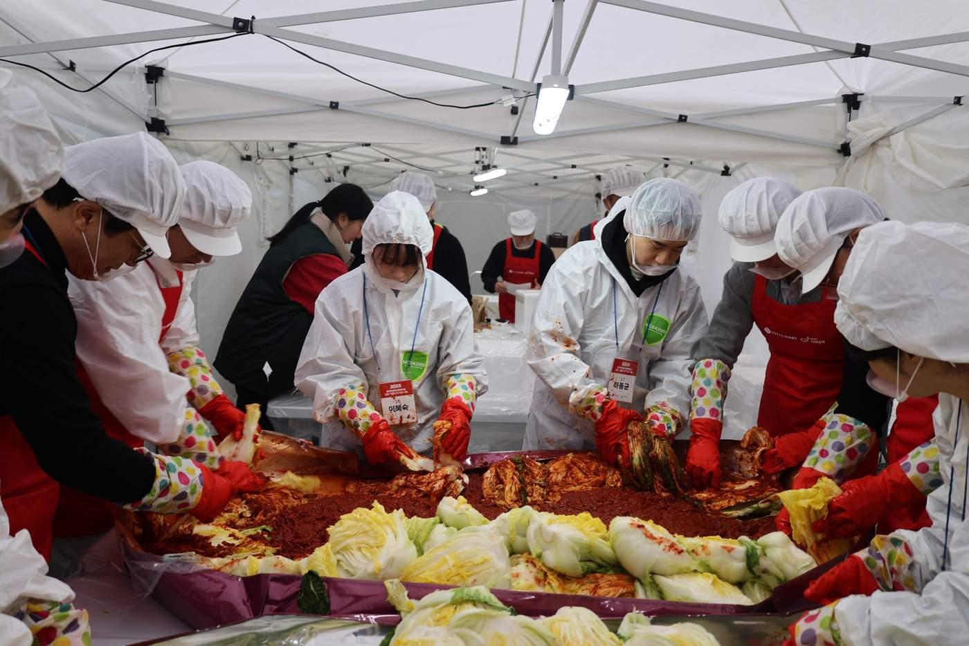  19일 서울시 송파구 문정노인종합복지관에서 열린 '사랑의 김장 나눔' 행사에서 롯데마트 임직원들이 취약계층에 전달할 김장 김치를 담그고 있다. (롯데마트 제공).