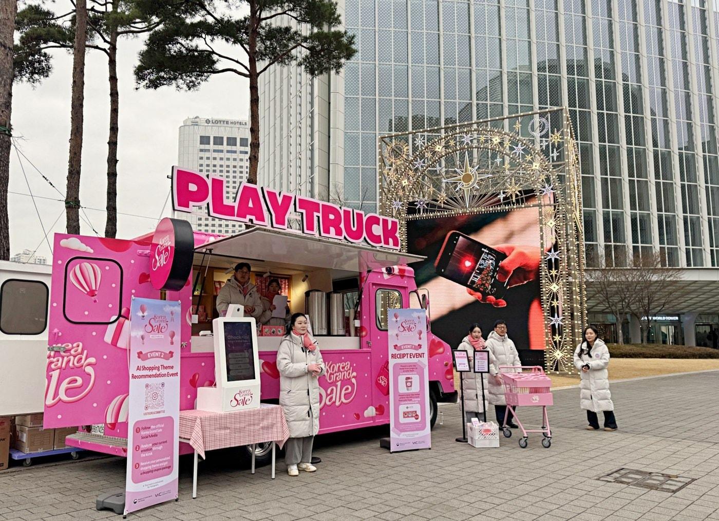 본문 이미지 - 잠실 롯데월드타워 월드파크 야외광장에 설치된 '플레이 팝업 트럭'에서 쿠폰을 받으려는 외국인 관광객.(롯데백화점 제공). 