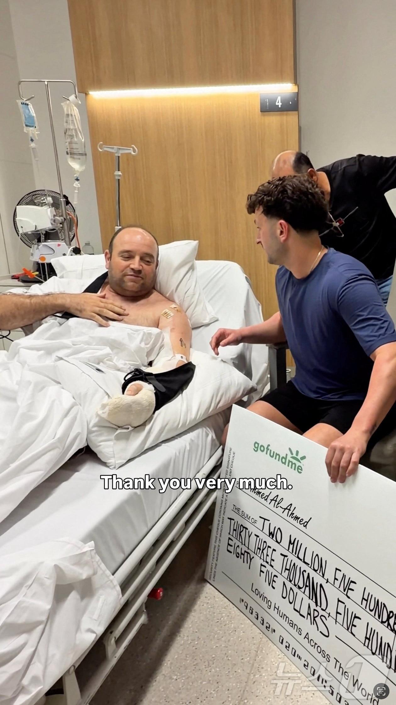 본문 이미지 - 호주 본다이비치 총기 난사 사건의 시민 영웅 아흐메드 알 아흐메드가 병상에서 후원금을 전달받는 모습. 2025.12.18. ⓒ 로이터=뉴스1 ⓒ News1 이지예 객원기자