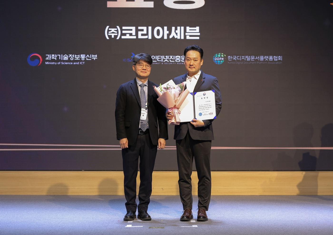 지난 1일 서울 SC컨벤션센터에서 개최된 &#39;2025 전자문서 산업인의 날&#39; 행사에서 문대우 세븐일레븐 디지털혁신부문장&#40;오른쪽&#41;이 엄열 과학기술정보통신부 국장&#40;왼쪽&#41;과 기념촬영을 하고 있다&#40;세븐일레븐 제공&#41;.