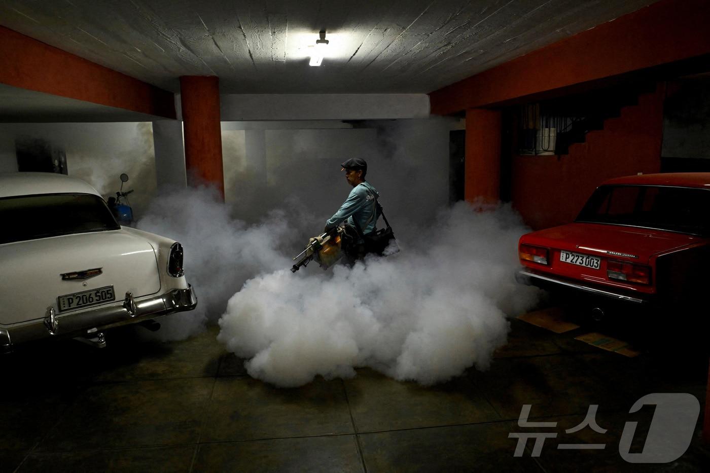지난달 13일&#40;현지시간&#41; 쿠바 아바나에서 모기 매개 질병 예방을 위한 공중 보건 캠페인이 진행되는 동안 보건 요원이 안개 살포기로 차고를 살균하고 있다. 2025.11.13. ⓒ 로이터=뉴스1 ⓒ News1 이정환 기자