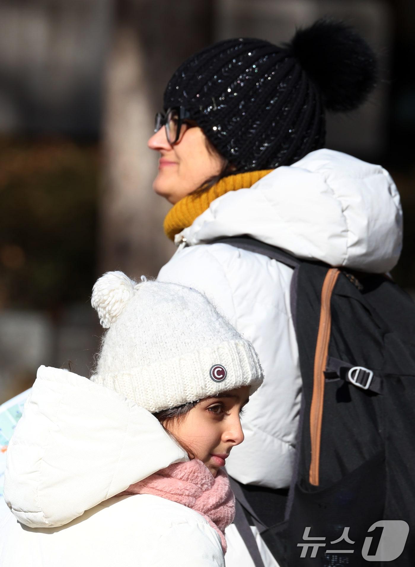 본문 이미지 - 휴일인 21일 서울 종로에서 외국인 관광객들이 추운 날씨속 연말을 보내고 있다.  2025.12.21/뉴스1 ⓒ News1 김명섭 기자