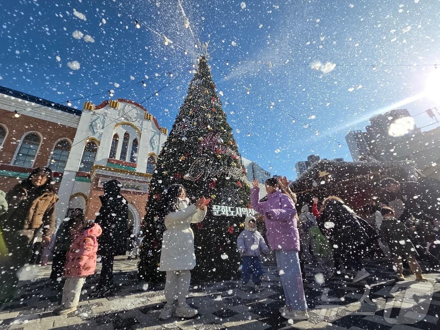 본문 이미지 - 21일 오후 2시께 전북 익산시 중앙동 익산근대역사관 광장에서 진행된 '인공 눈 퍼포먼스'를 시민들이 즐기고 있다.2025.12.21/뉴스1 문채연 기자 ⓒ News1 문채연 기자