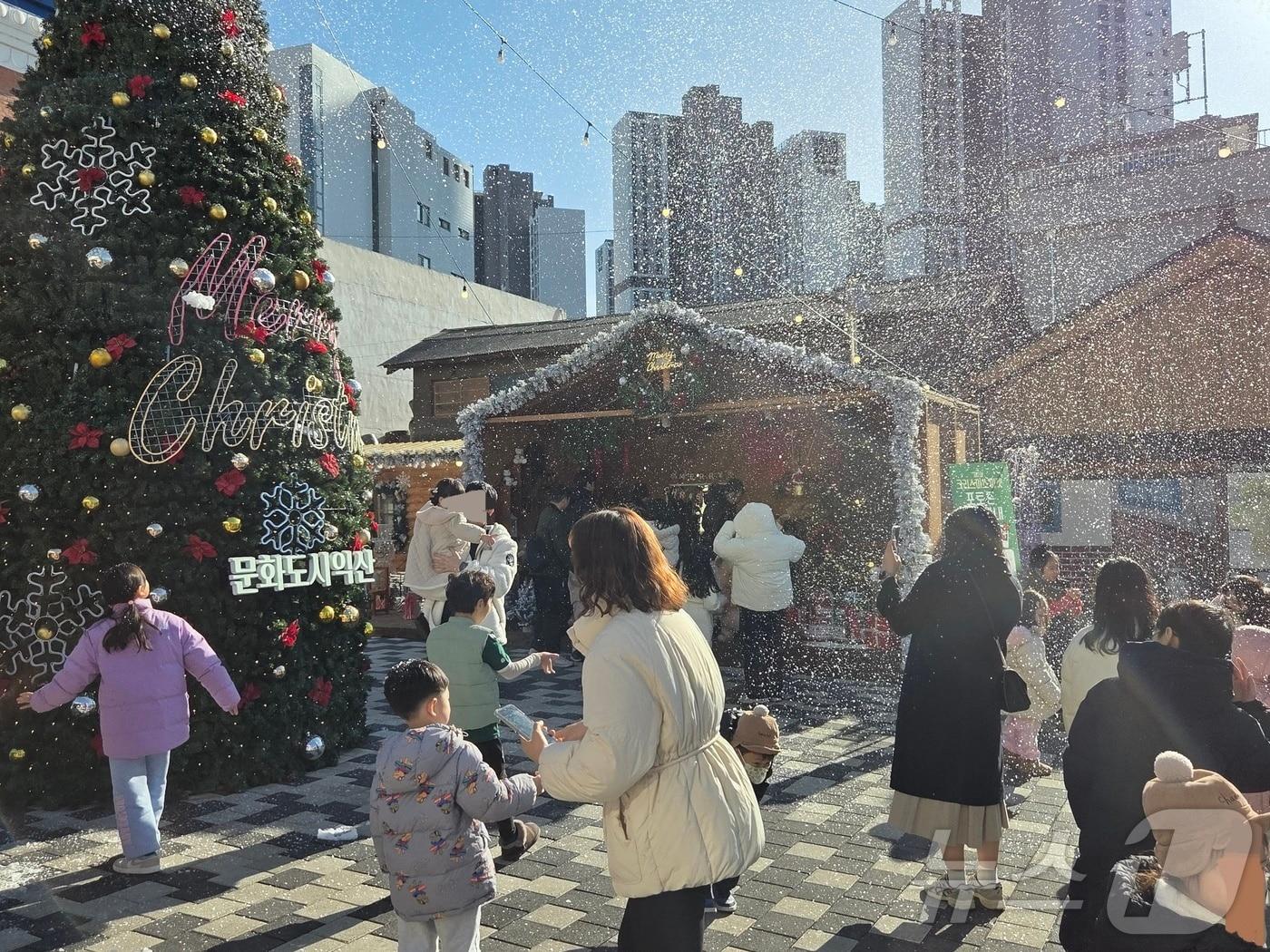본문 이미지 - 21일 오후 2시께 전북 익산시 중앙동 익산근대역사관 광장에서 진행된 '인공 눈 퍼포먼스'를 시민들이 즐기고 있다.2025.12.21/뉴스1 문채연 기자 ⓒ News1 문채연 기자