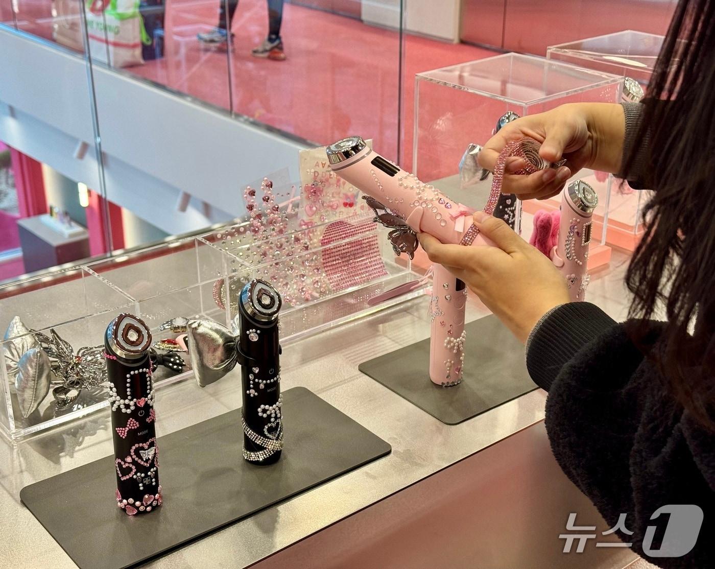 본문 이미지 - 메디큐브 성수에서 한 방문객이 뷰티 디바이스 꾸미기를 체험하고 있다. ⓒ News1 이민주 기자