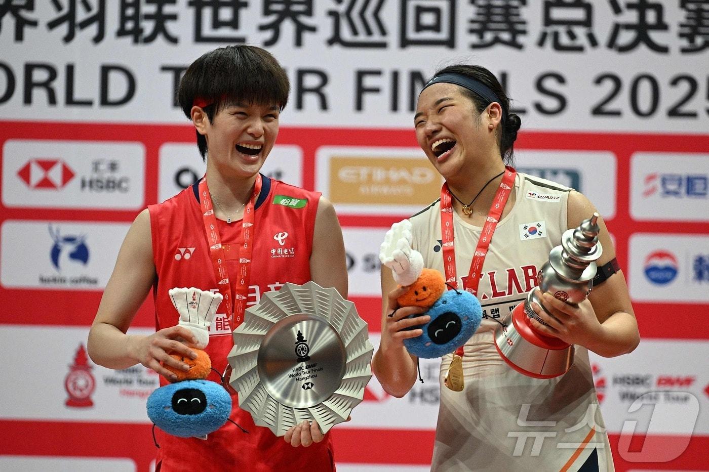 본문 이미지 - 금메달을 딴 안세영(오른쪽)이 2025년 12월21일 중국 항저우 올림픽스포츠센터 체육관에서 열린 세계배드민턴연맹(BWF) 월드 투어 파이널 여자단식 시상식에서 은메달을 딴 중국의 왕즈이와 포즈를 취하고 있다. 안세영이 여자단식 세계랭킹 1위, 왕즈이는 2위다. ⓒ AFP=뉴스1