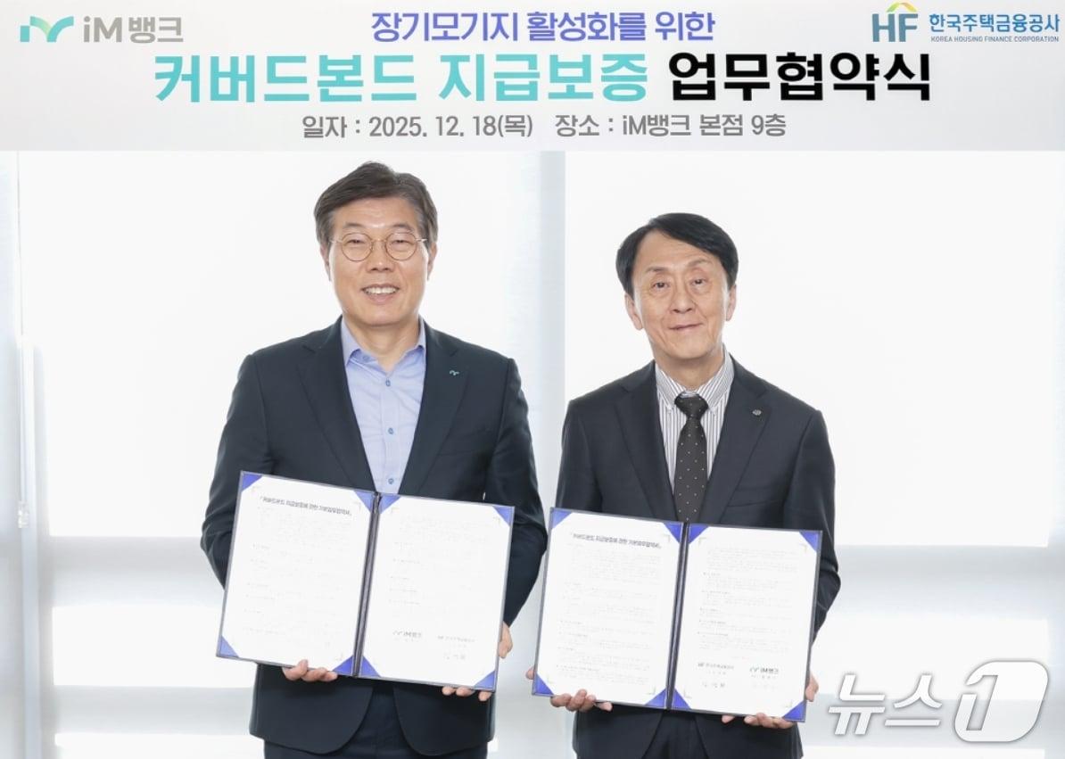 본문 이미지 - 황병우 iM뱅크 은행장(왼쪽)과 김경환 한국주택금융공사 사장이 커버드본드 지급보증 업무협약을 체결한 뒤 협약서를 펼쳐 보이고 있다.(iM뱅크 제공, 재판매 및 DB 금지)