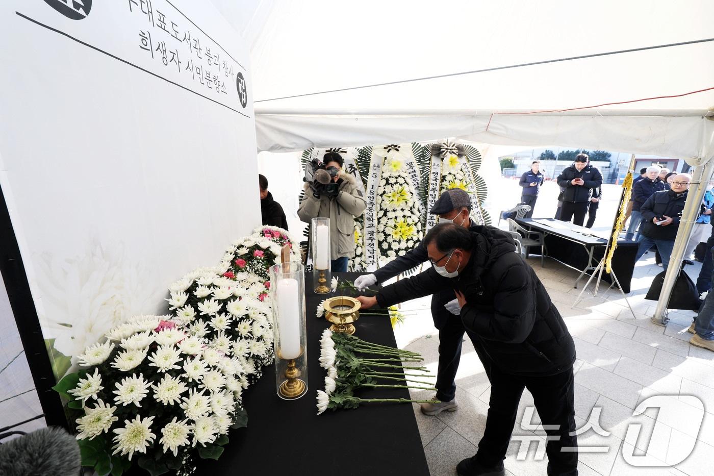 광주대표도서관 붕괴사고 유가족들이 22일 오전 광주 동구 5·18민주광장에 마련된 '광주대표도서관 붕괴 참사 희생자 시민 분향소'에서 헌화하고 있다. ⓒ News1 이승현 기자
