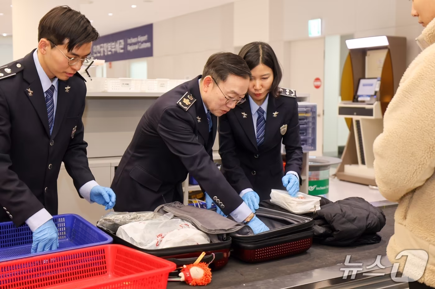  이명구 관세청장(가운데)이 22일 오전 인천국제공항 제1여객터미널에서 직접 여행자 휴대품을 검사하고 있다. (관세청 제공.재판매 및 DB금지)/뉴스1