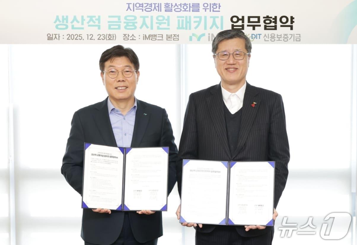 본문 이미지 - 황병우 iM뱅크 은행장(왼쪽)과 최원목 신용보증기금 이사장이 지역 경제 활성화를 위한 생산적 금융지원 패키지 업무협약을 체결한 후 협약서를 펼쳐 보이고 있다.(iM뱅크 제공, 재판매 및 DB 금지)