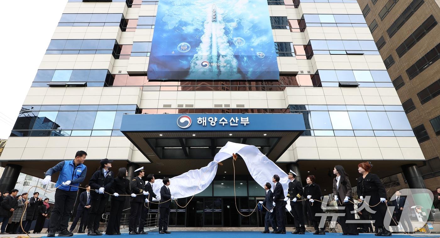 본문 이미지 - 이재명 대통령이 23일 부산 동구 해양수산부 청사에서 열린 개청식에서 제막식을 하고 있다. 오른쪽부터 해수부 이석민 주무관 모친 정성미 씨, 박은혜 해수부 주무관, 이희숙 원조콩나물비빔밥 사장, 이대규 SK해운 선장, 박형준 부산시장, 김성범 해수부 장관 직무대행, 이재명 대통령, 김민석 총리, 구본민 한국해양대학교 학생, 박혜라 씨드(SEA.D) 대표, 윤경희 에이치라인해운 2등 항해사, 윤병철 해수부 주무관. (대통령실통신사진기자단) 2025.12.23 ⓒ 뉴스1 이재명 기자