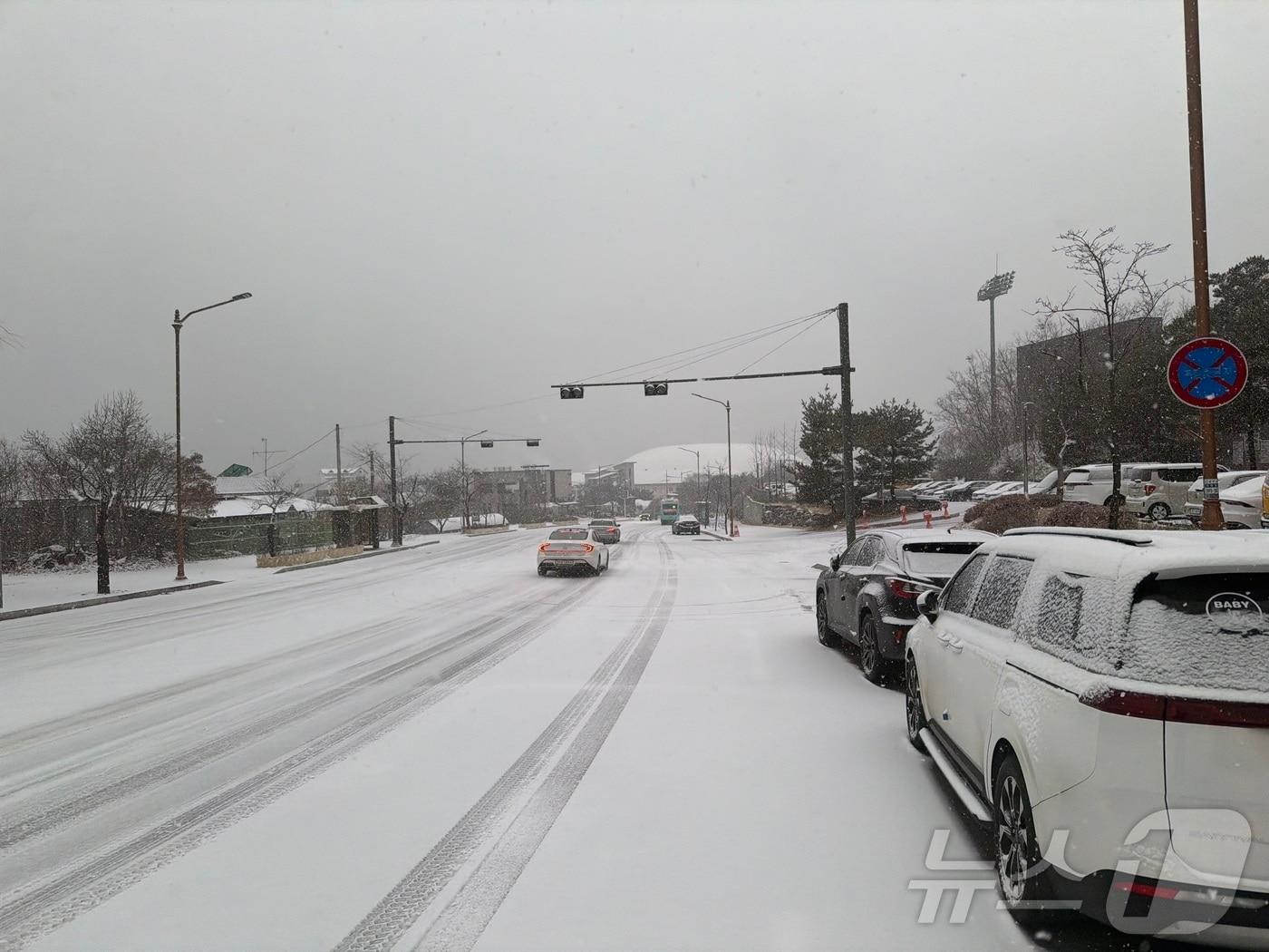 본문 이미지 - 23일 오후 강원 춘천 송암동 일대에 눈이 내리자 차들이 속도를 줄여 지나가고 있다. 2025.12.23/뉴스1 ⓒ News1 한귀섭 기자