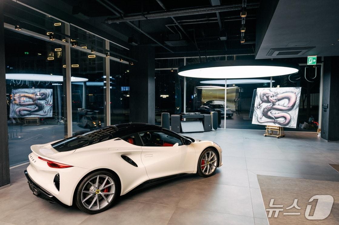 본문 이미지 - 21일 서울 강남 도산대로 소재 로터스 플래그십 전시장에서 일본 아티스트 다이몬 료타가 선보인 라이브 페인팅 작품이 로터스 스포츠카 '에미라'와 함께 전시된 모습(로터스자동차코리아 제공). 2025.12.21.