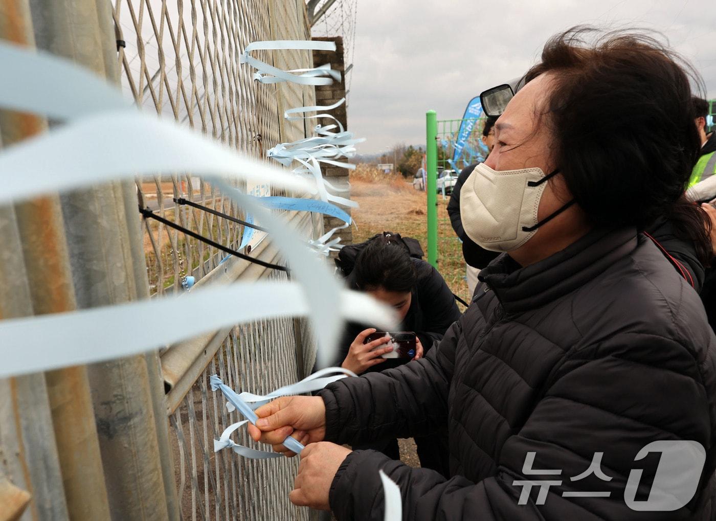 본문 이미지 - 12·29 제주항공 여객기 참사 1주기를 앞둔 24일 전남 무안국제공항에서 유가족들이 추모 리본을 작성해 달고 있다. 2025.12.24/뉴스1 ⓒ News1 박지현 기자