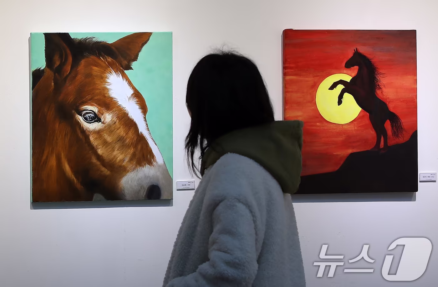 24일 대구 동구 아양아트센터에서 개막한 '2026 병오년(丙午年) 새해맞이 말(馬) 그림전'을 찾은 시민들이 역동적인 '붉은 말'의 해를 맞아 더 높이 비상하는 희망찬 새해를 기원하는 작품을 감상하고 있다. 2025.12.24/뉴스1 ⓒ News1 공정식 기자