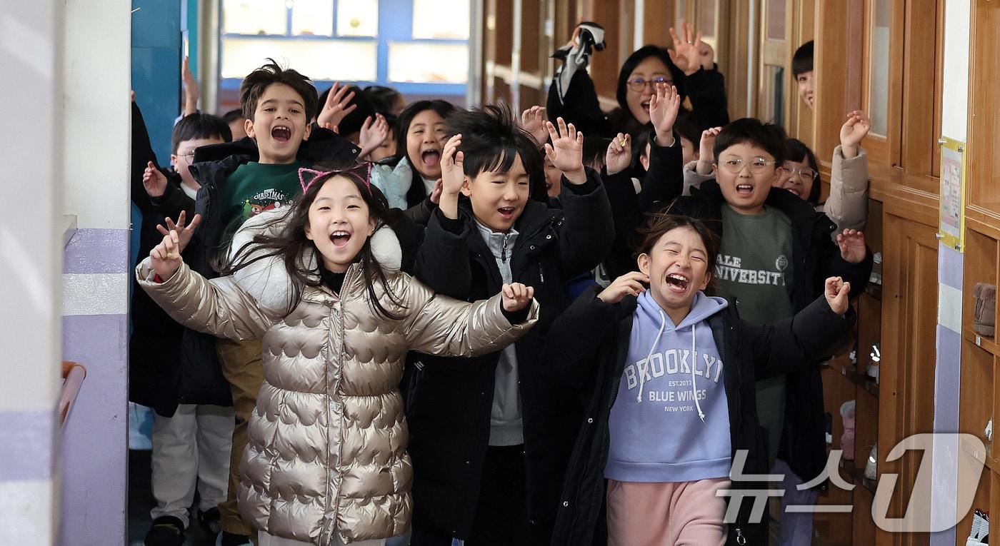 본문 이미지 - 24일 서울 동대문구 안평초등학교에서 2학년 학생들이 겨울방학식을 마친 뒤 밝은 표정으로 하교하고 있다. 2025.12.24 ⓒ 뉴스1 박지혜 기자