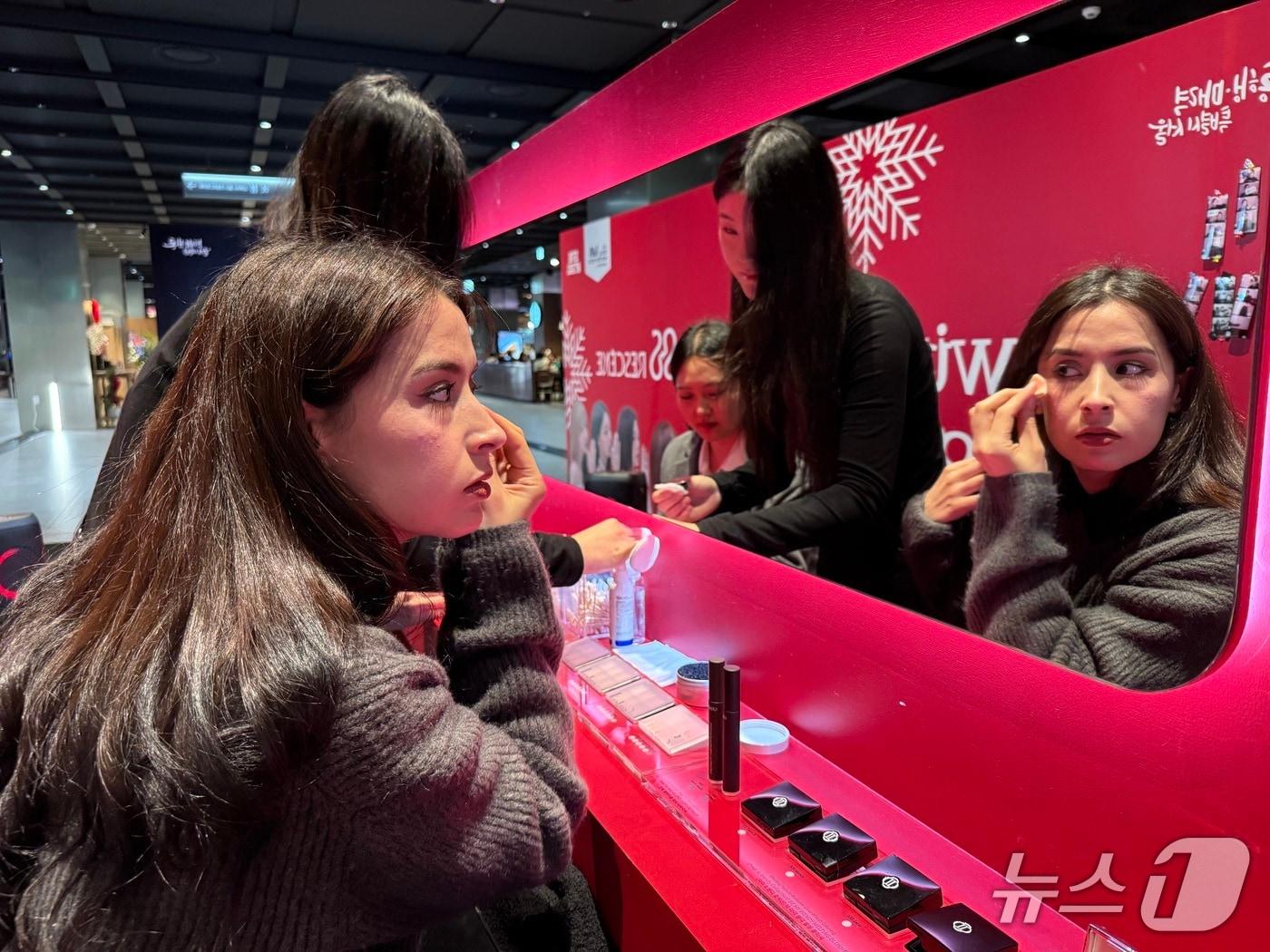 본문 이미지 - 24일 서울 종로구 KT 광화문 WEST에서 열린 '윈터 글램 서울' 딘토 뷰티 체험 클래스에서 참가자가 화장품을 발라보고 있다.  2025.12.24/뉴스1 ⓒ News1 이비슬 기자