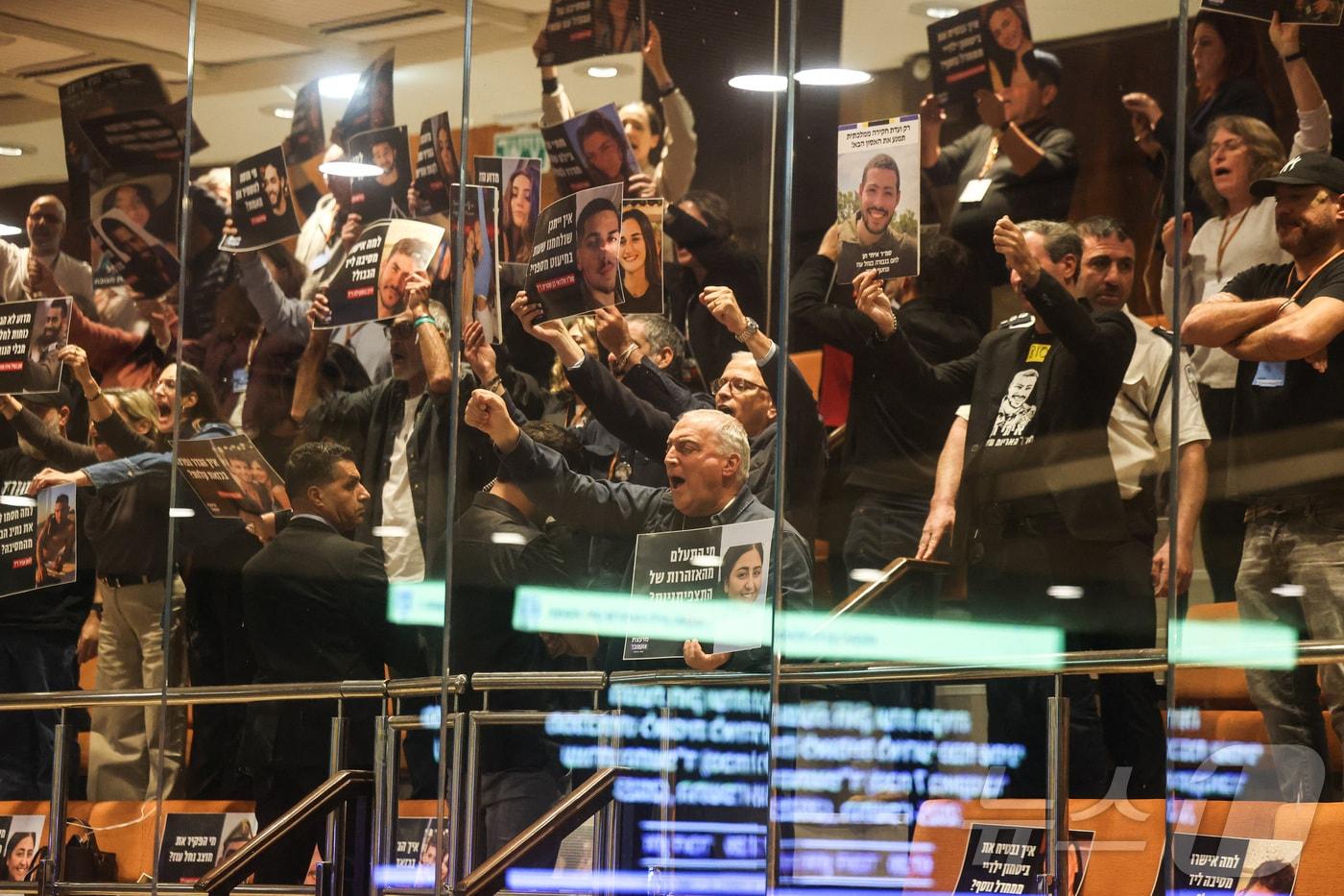 24일(현지시간) 이스라엘 예루살렘에 있는 이스라엘 의회 본회의장 상단에서 '10월 위원회(October Council)' 회원들이 시위를 벌이고 있다. 전직 인질들과 희생자 가족들로 구성된 이 단체는 2023년 10월 7일 하마스의 공격을 초래한 안보 실패에 대해 독립적인 국가조사위원회 설치를 요구하고 있다. 2025.12.24 ⓒ 로이터=뉴스1 ⓒ News1 최종일 선임기자