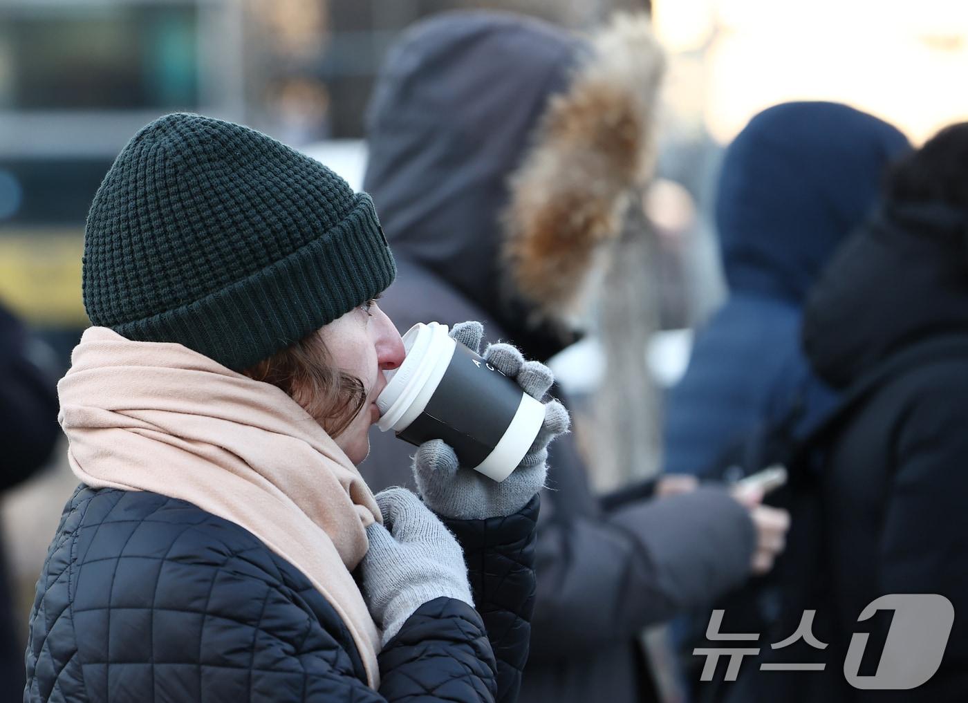 본문 이미지 - 체감 -20도 안팎의 올겨울 최강 한파가 찾아온 26일 오전 서울 종로구 광화문네거리에서 한 외국인이 뜨거운 음료를 마시고 있다. ⓒ News1 김민지 기자