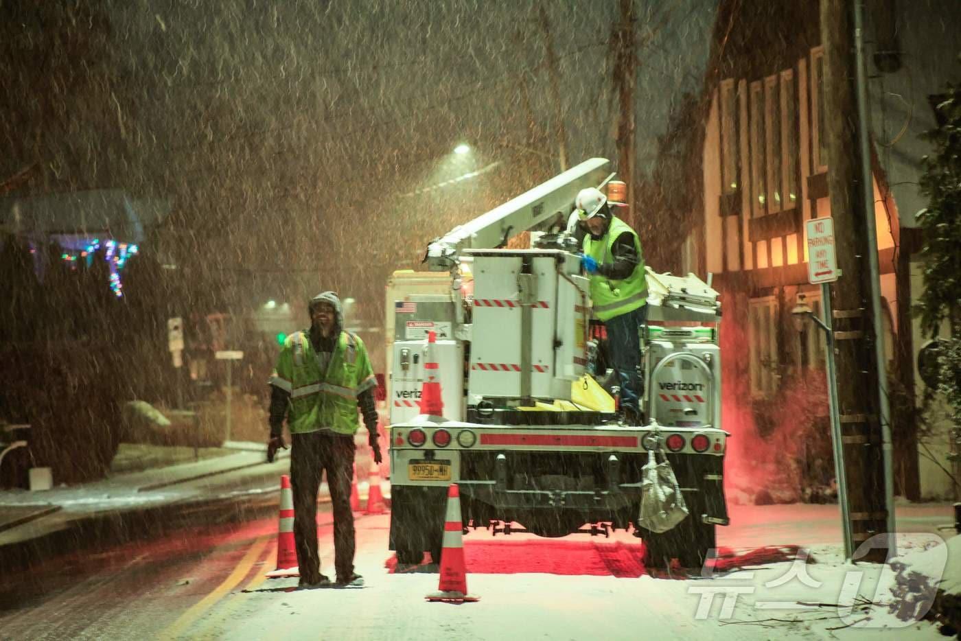 26일(현지시간)  뉴욕주 피어몬트(Piermont)에서 공공시설 서비스(Utility) 직원들이 쏟아지는 눈발을 뚫고 긴급 복구 작업을 진행하고 있다. 이날 뉴욕을 포함한 트라이스테이트(Tri-State) 지역에는 최대 12인치(약 30cm)의 기록적인 폭설이 예고되면서 비상사태가 선포되었으며, 기상 당국은 금요일 26일 저녁부터 토요일 27일 오전까지를 이번 폭풍의 최대 고비로 전망했다. ⓒ AFP=뉴스1