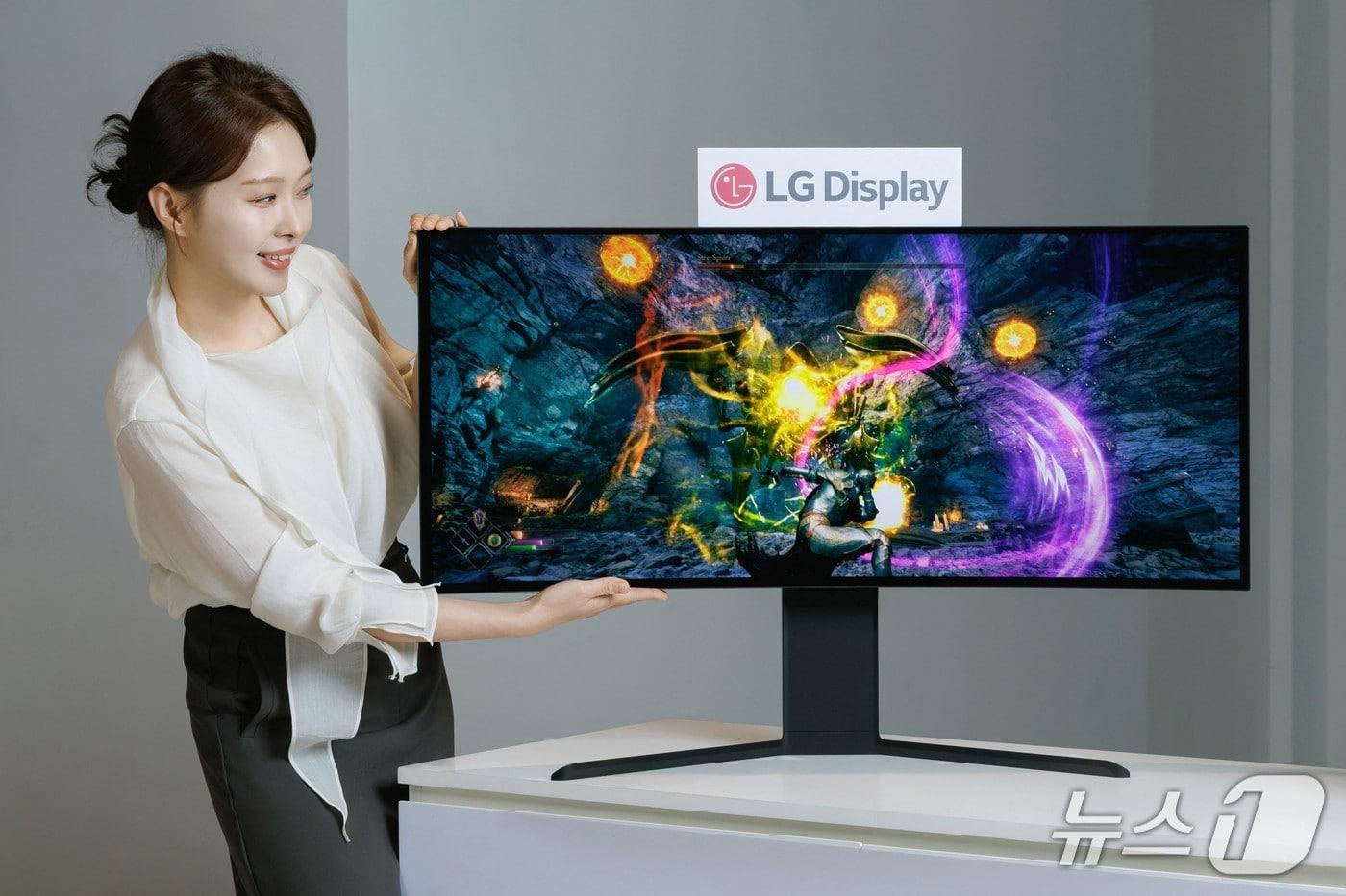 LG디스플레이 임직원이 모니터용 OLED 패널 중 최고 해상도인 5K2K 화질을 구현하는 39인치 제품을 선보이고 있다. (사진제공 = LG디스플레이) 