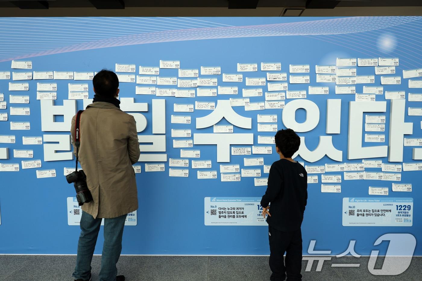 12·29 여객기 참사 1주기인 29일 전남 무안국제공항 내 추모의벽에서 시민들이 탑승권 형식의 추모메시지를 읽으며 추모하고 있다. 2025.12.29/뉴스1 ⓒ News1 박지현 기자