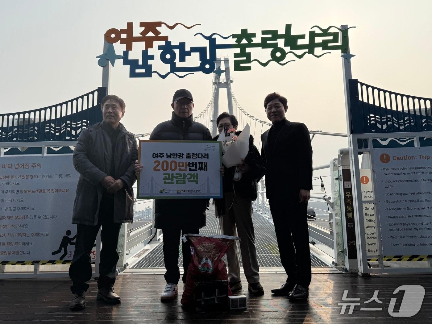 본문 이미지 -  경기 여주시가 남한강 출렁다리 200만 번째 방문객에게 기념 선물을 주고 사진을 찍고 있다.(여주시 제공. 재판매 및 DB 금지)/뉴스1