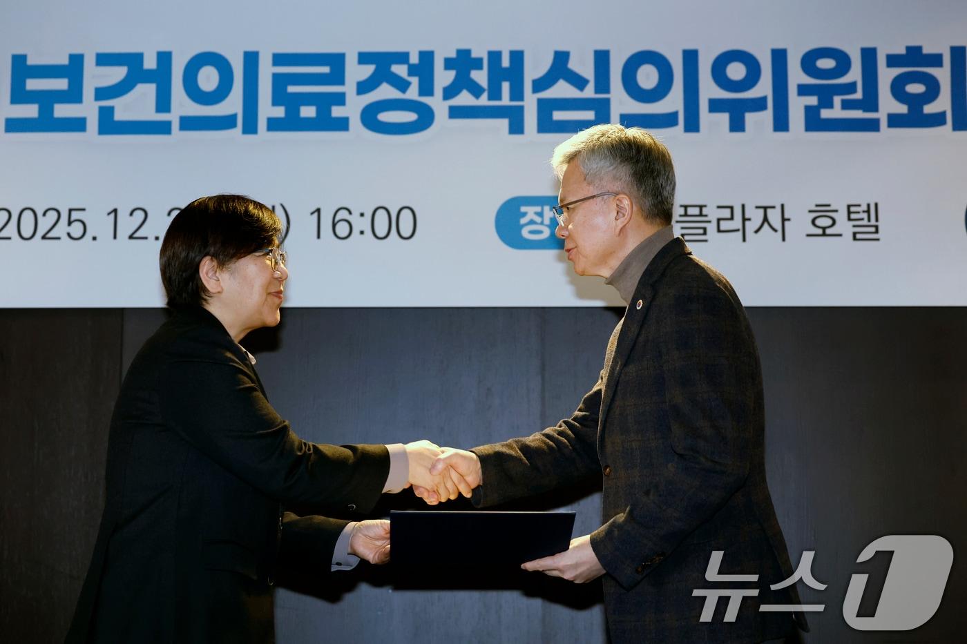 정은경 보건복지부 장관이 29일 오후 서울시 중구 소공로 더 플라자 호텔 서울에서 열린 2025년 제1차 보건의료정책심의위원회 회의에서 김택우 대한의사협회장에게 위촉장을 수여하고 있다. 2025.12.29/뉴스1 ⓒ News1 박정호 기자