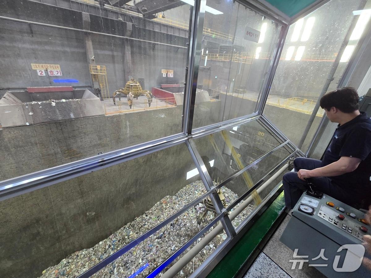 본문 이미지 - 청라소각장 제어실에서 직원이 크레인을 통해 저장조에 쌓인 폐기물을 집어올리고 있다. / 뉴스1 ⓒ News1 유준상 기자