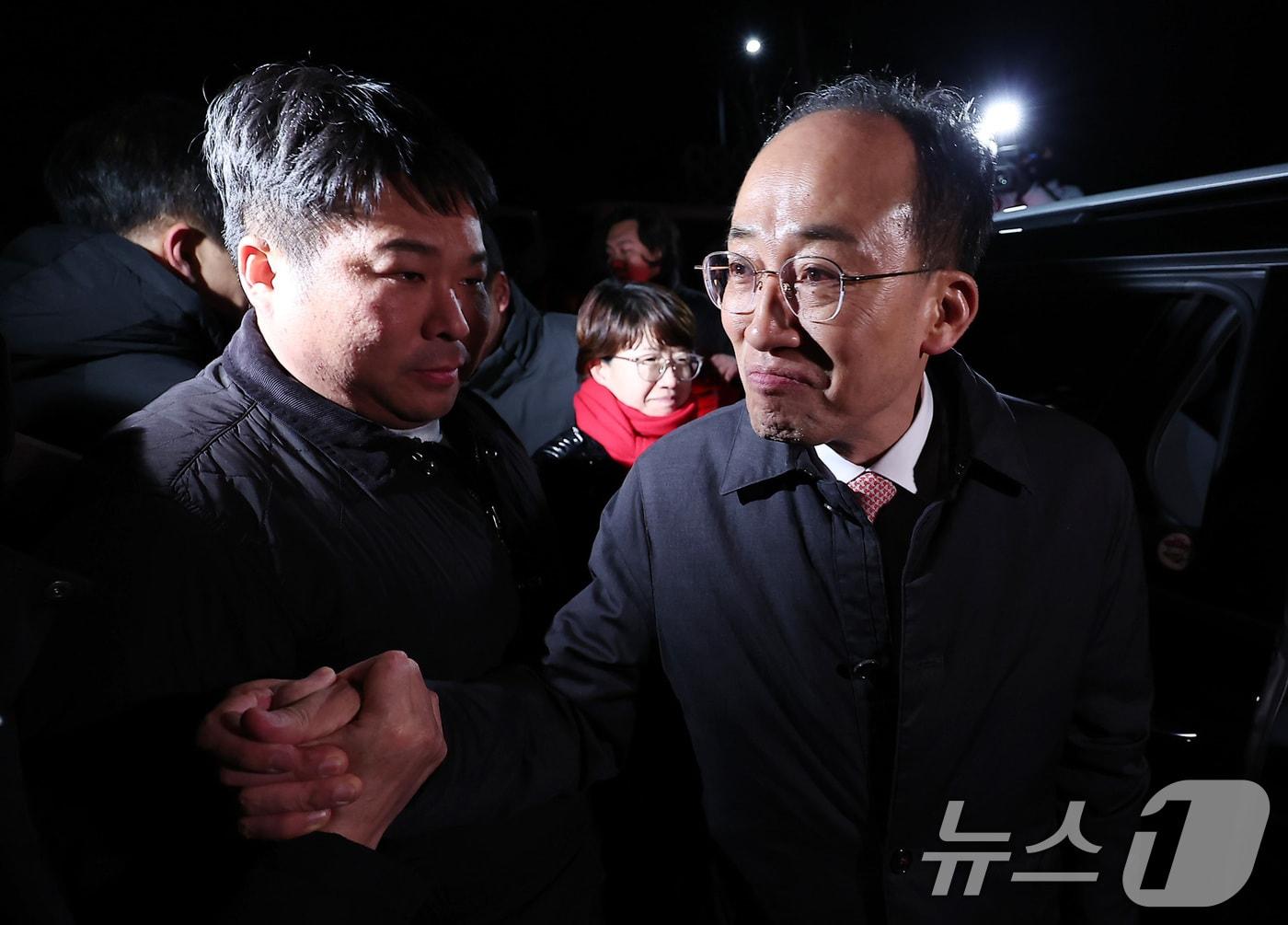 본문 이미지 - 12·3 비상계엄 해제 요구안 표결 방해 의혹을 받는 추경호 국민의힘 의원이 3일 새벽 구속 영장이 기각된 후 경기도 의왕시 서울구치소를 나서며 동료 의원들과 인사하고 있다. 2025.12.3/뉴스1 ⓒ News1 김성진 기자