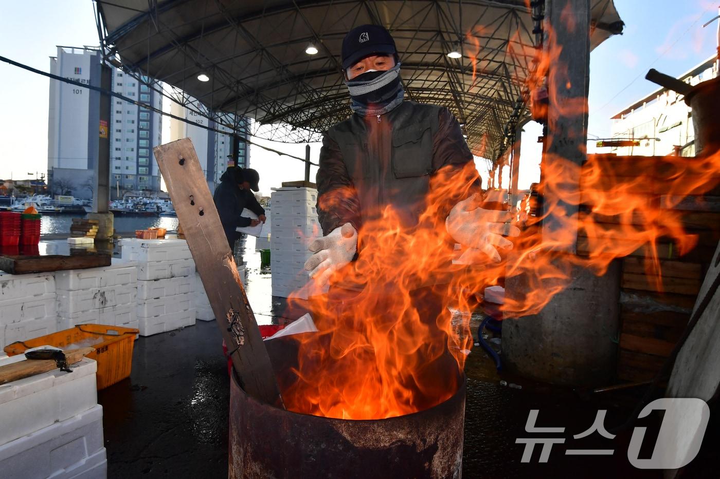 경북 포항의 아침기온이 영하로 떨어진 지난 3일 포항시 죽도어시장에서 상인들이 장작불에 몸을 녹이고 있다. 2025.12.3/뉴스1 ⓒ News1 최창호 기자