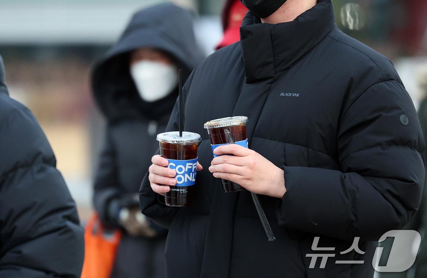 본문 이미지 - 서울 종로구 광화문네거리에서 두터운 옷차림을 한 시민이 차가운 음료를 들고 발걸음을 옮기고 있다. 2025.12.3/뉴스1 ⓒ News1 이호윤 기자